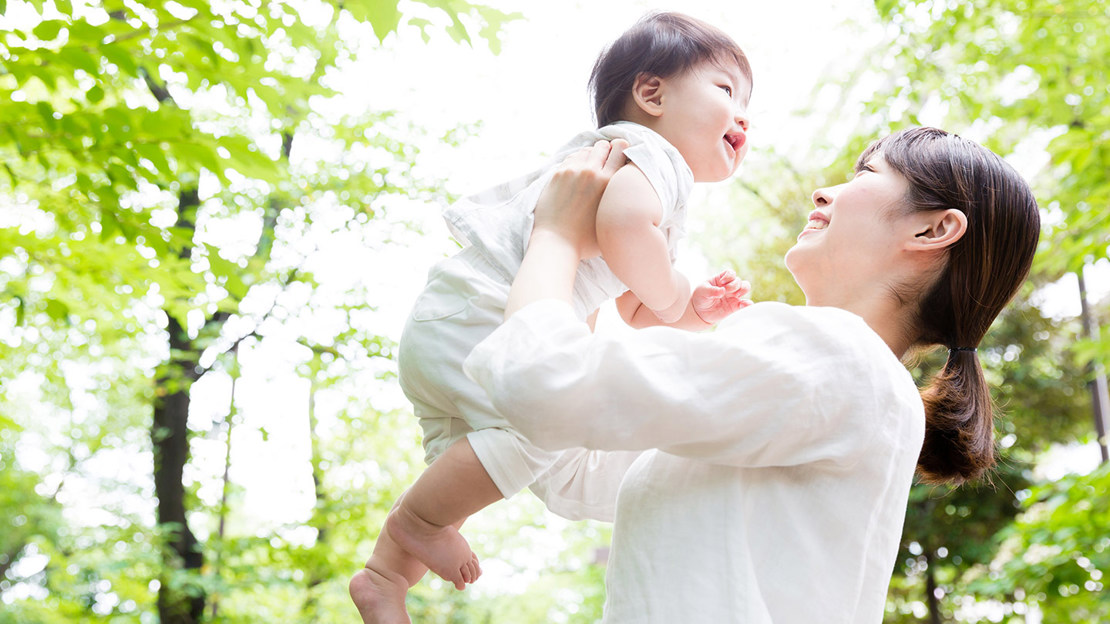 Mother holding up baby