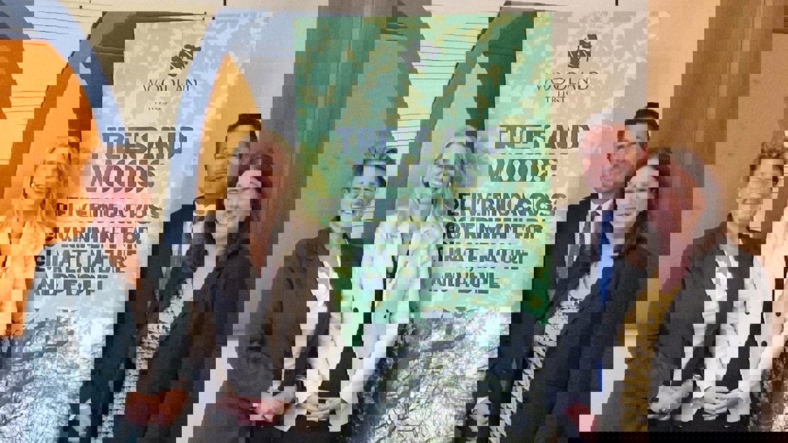 Four people standing next to a Woodland Trust promtional banner