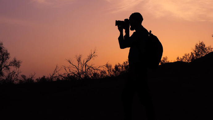 silhouette of photographer taking photo at sunset