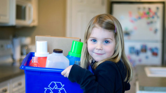 Schoolgirl holding a box of recycling