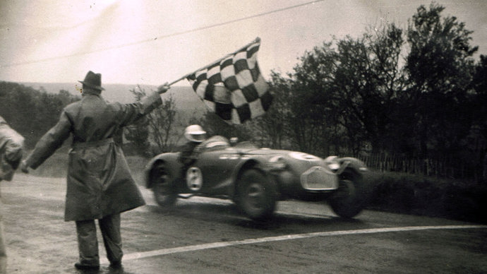 Sepia image of Kenneth Watkins crossing a finish line in a racing car