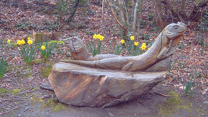 Wooden memorial carving, circled by daffodils