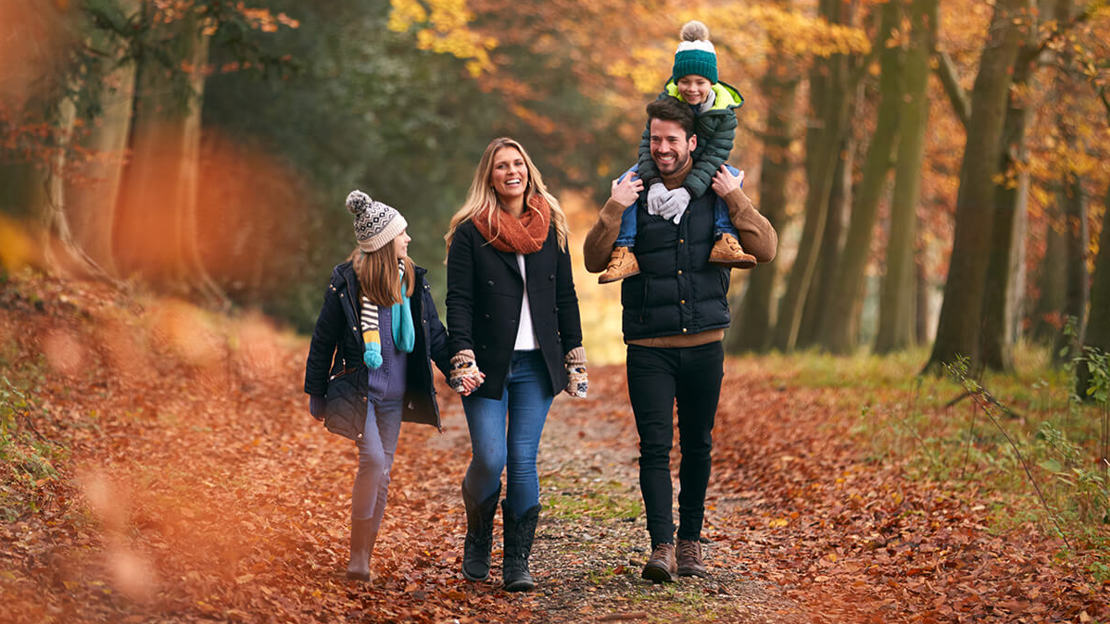 Family walking through a wood in autumn