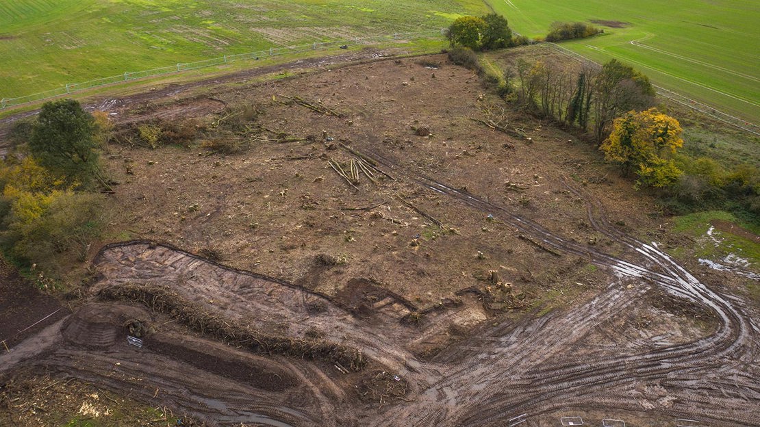 Aerial view of bare earth where ancient woodland has been felled