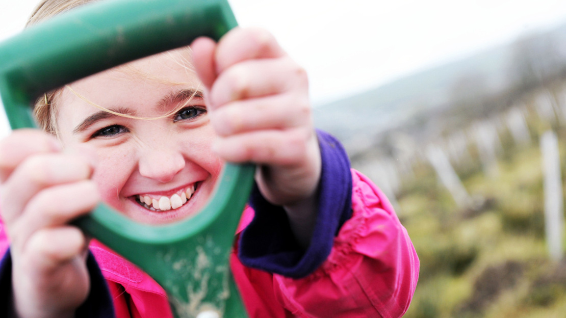 Young girl smiling with a spade
