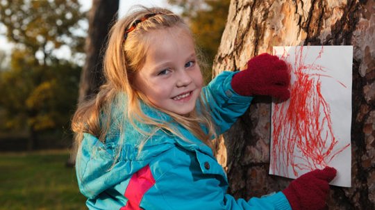 Girl making bark rubbing