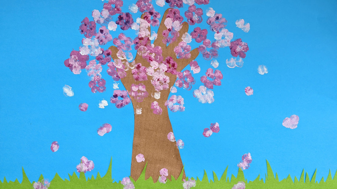 A child's finger painting of a pink cherry blossom tree