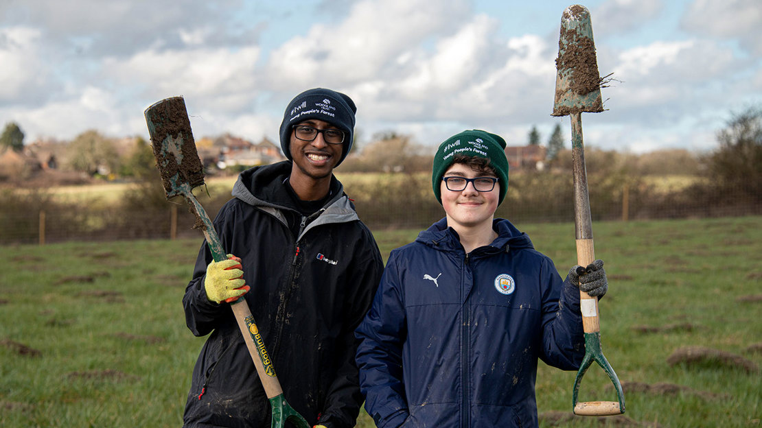 Teenagers holding spades at The Young Peoples Forest at Mead