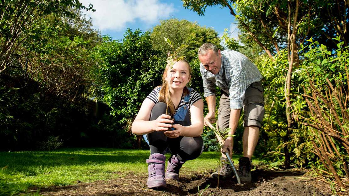Family planting a tree in the garden