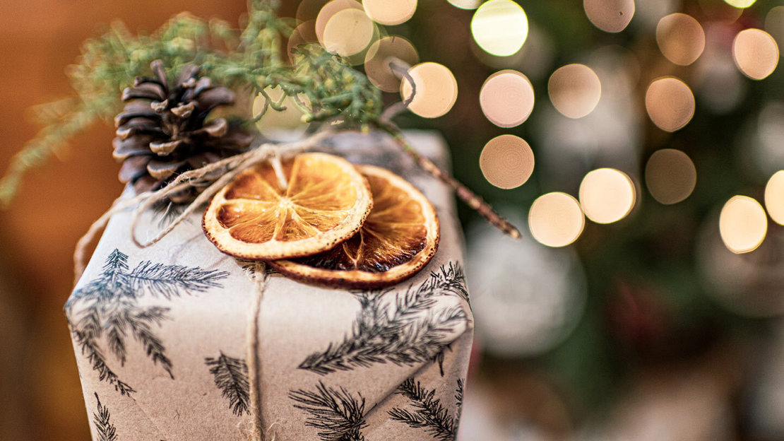 Christmas present topped with pinecone and orange slices