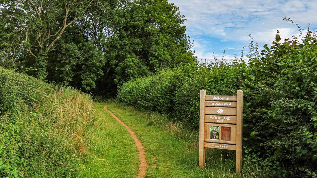 Wecome sign next to grassy path
