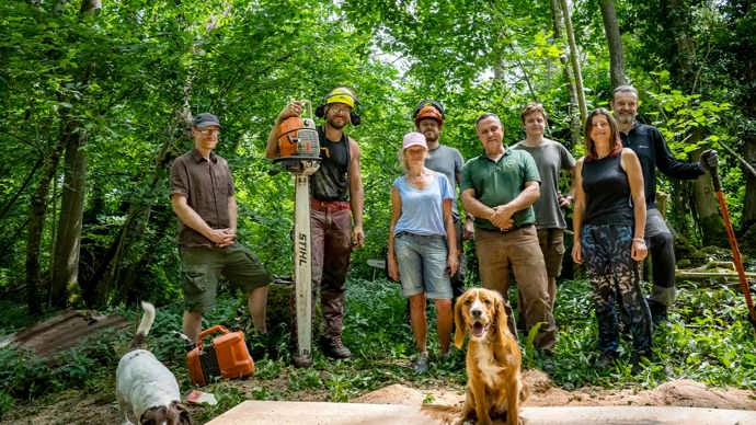 Group of volunteers pose for a photo in the woods