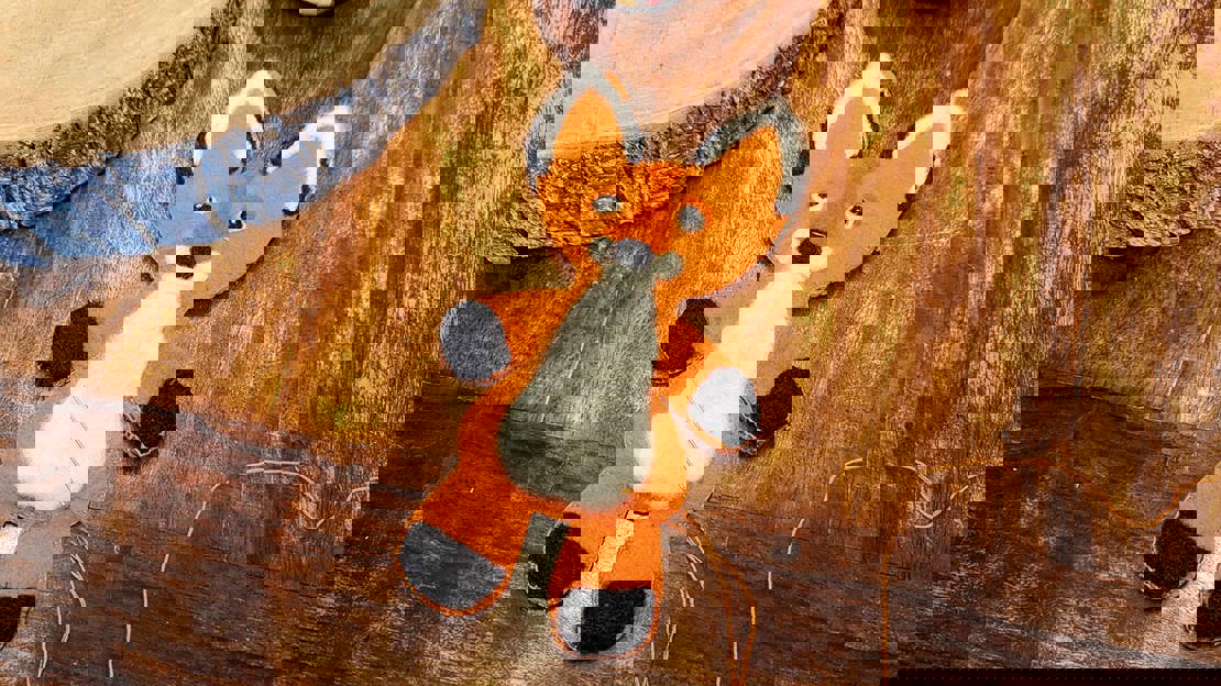 A felt fox being sewn up with a needle and thread