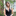 Head and shoulders shot of Woodland Trust trustee, Amber Thiara, with a background of tree branches