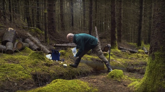Volunteer Brian Palmer taking a sample from a woodland stream