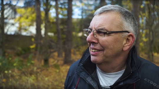 Volunteer Andy Black in a wood talking to camera