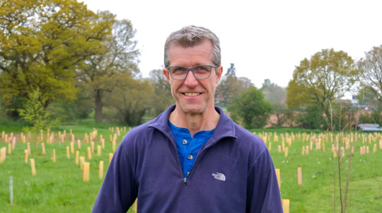 Mark Lea on his organic farm in Shropshire in front of a newly planted woodland