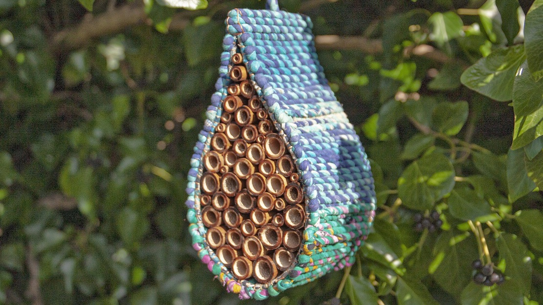 Teardrop shaped nester in bright colours packed with natural bamboo sticks