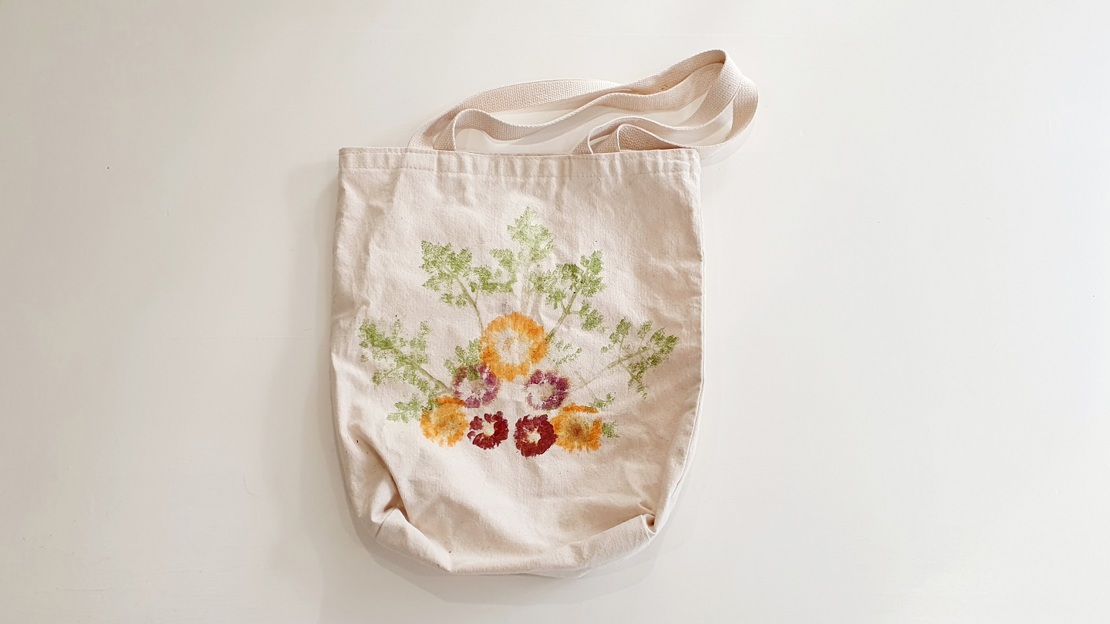 A canvas tote bag with colourful flower print artwork on