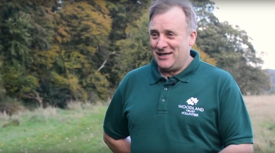Volunteer Lionel Knobbs in a wood facing the camera
