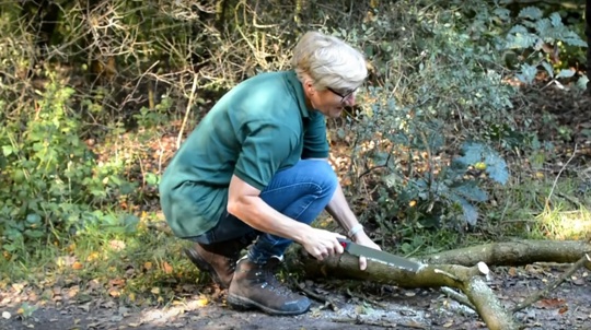 Volunteer Joanne Yellen sawing a branch