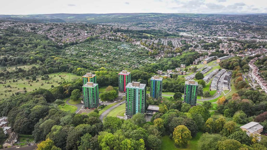 An aerial shot of blocks of flats and houses surrounded by trees and greenery