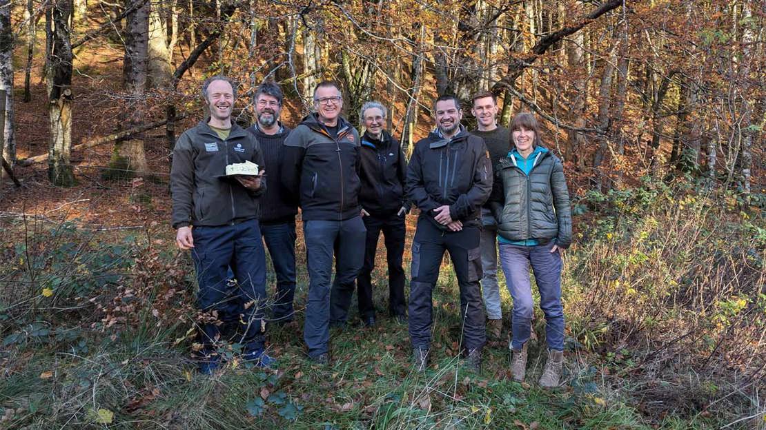 Beò Airceig project partners posing for group photo in front of beech trees.