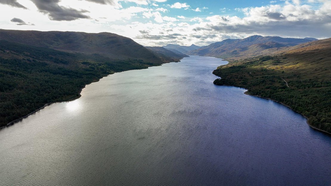 Aerial view above Loch Arkaig looking towards distant mountains.