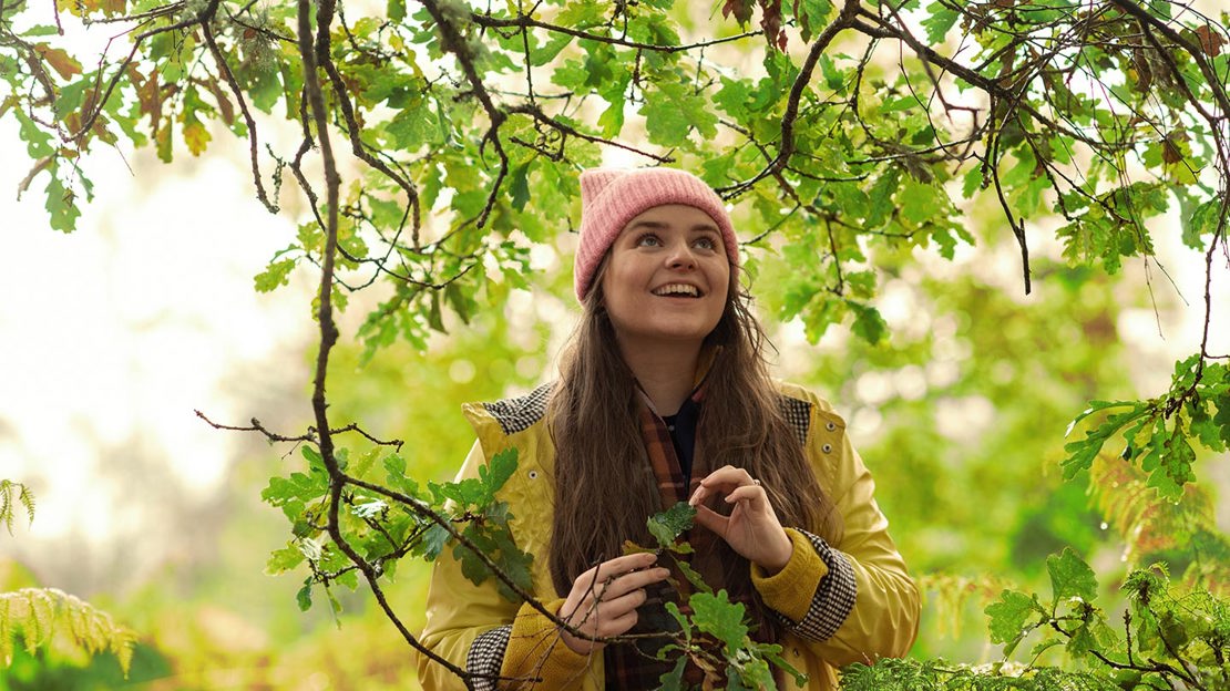 Young person looking up in woods