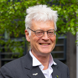 Profile image of James Ogilvie with leafy background.