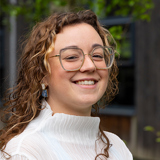 Profile image of Briony Nesbitt with leafy background.